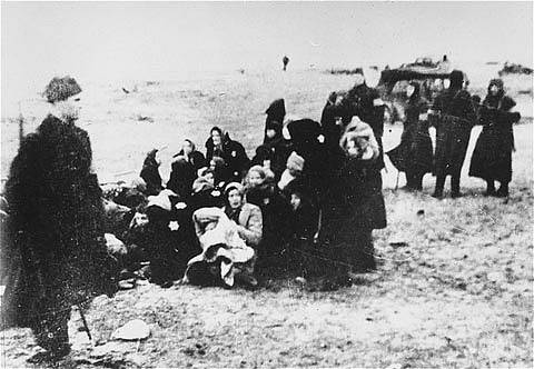 Židovské ženy a děti hlídané krátce před svým zavražděním příslušníky lotyšské policie v roce 1941. Tento snímek zachycuje událost v lotyšském přístavu Liepaja