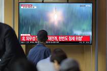Lidé na vlakovém nádraží v jihokorejském Soulu sledují televizní reportáž o raketovém testu, který 6. října 2022 provedla KLDR