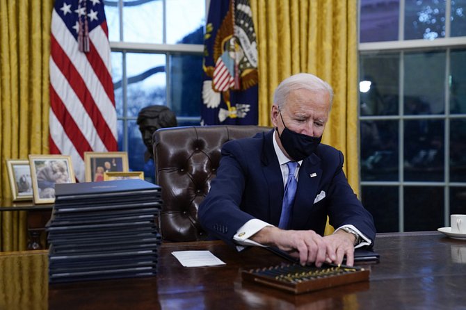 Nový americký prezident Joe Biden podepisuje první dokumenty v Oválné pracovně Bílého domu.