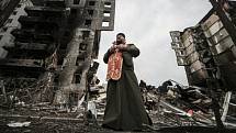 Kněz se modlí za oběti útoků uprostřed vybombardovaného sídliště v Boroďance.
