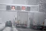 Kamiony na dálnici během hustého sněžení.  Ilustrační foto.