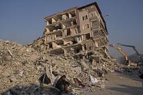 Muž sedící v troskách budovy zřícené při zemětřesení v tureckém městě Antakya