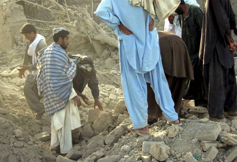 Lidé prohledávají trosky po náletu ve vesnici Ganj Abad v okrese Bala Buluk v afghánské provicii Farah.