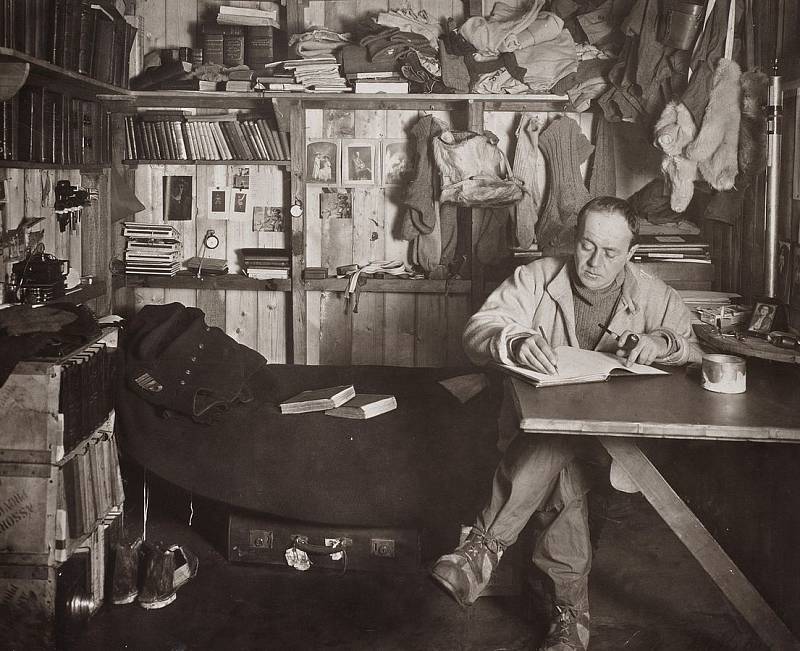Robert Falcon Scott v zásobovací stanici, kde píše deník