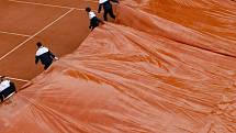 Pořadatelé French Open při dešti zakrývají kurt plachtou.