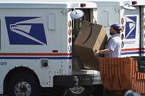Zaměstnanec americké pošty (USPS) nakládá do automobiliu zásilku