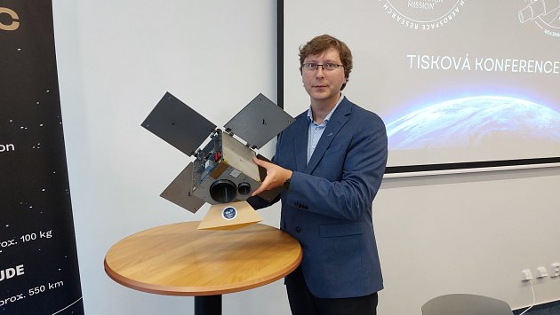 Zmenšenina české družice Ambic v rukou vedoucího vědeckého pracovníka VZLÚ Vladimíra Dániela.