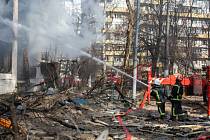 Hasiči v kyjevě hasí požár budovy po bombovém útoku ruské armády.