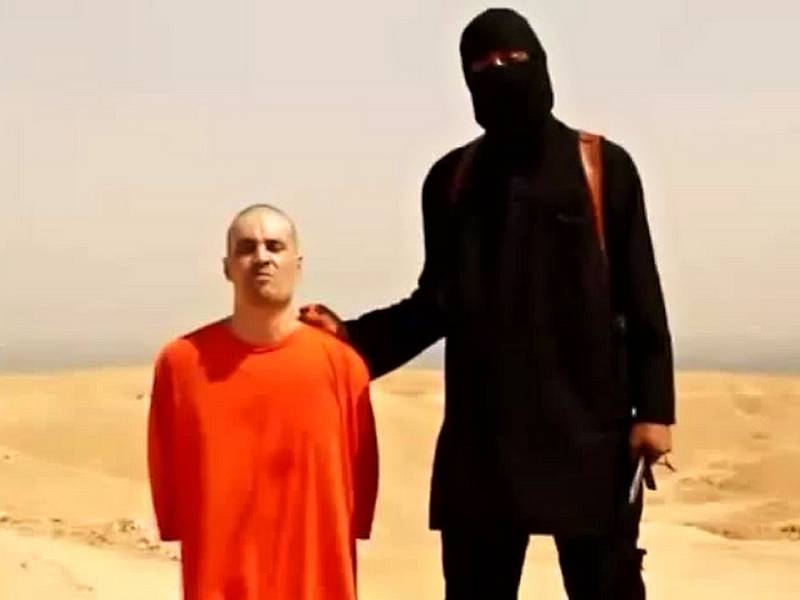 Klečící novinář James Foley krátce před svou smrtí.