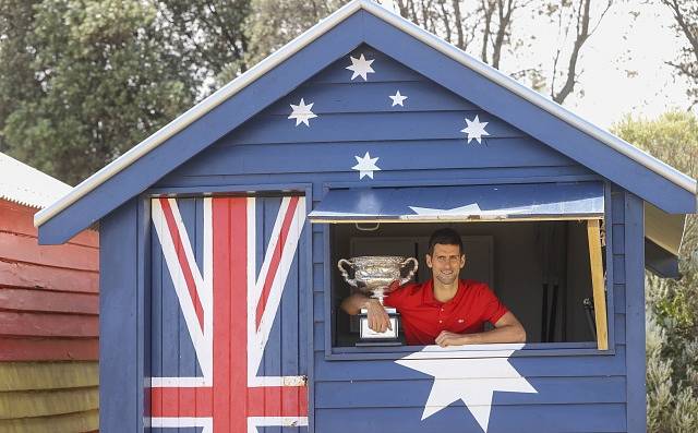 Novak Djokovič pózuje s trofejí po svém loňském triumfu na Australian Open