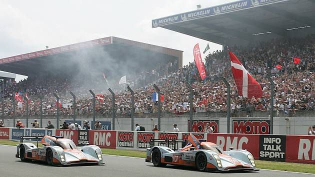 Dvojice Aston Martinů protíná cílovou čárů v Le Mans. S číslem 007 jela posádka Enge, Charouz, Mücke.