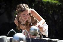 Žena se občerstvuje vodou z pítka v horkém odpoledni 18. června 2021 v Praze.