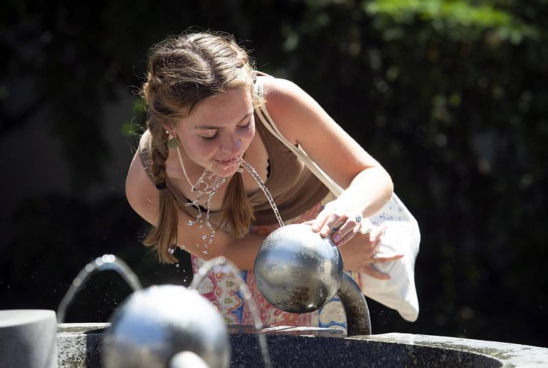 Žena se občerstvuje vodou z pítka v horkém odpoledni 18. června 2021 v Praze.