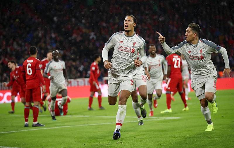 Slavící fotbalisté Liverpoolu Virgil Van Dijk (uprostřed) a Roberto Firmino (vpravo).