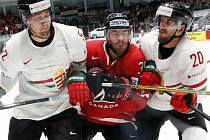Boone Jenner z Kanady (uprostřed) se snaží prosadit mezi hokejisty Běloruska.
