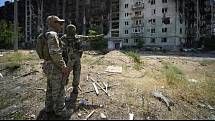 Ruští vojáci u zničených obytných budov v ukrajinském Severodoněcku, 12. července 2022