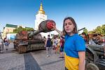 Mykhailivska Square. Na Náměstí svatého Michala v Kyjevě stojí jako válečné memento trosky poničené ruské techniky. Dívka symbolicky basketbalovým míčem zakrývá hlaveň tanku.