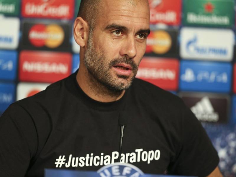 Trenér Bayernu Mnichov Pep Guardiola přišel na tiskovou konferenci v tričku s nápisem #JusticiaParaTopo, kterým podpořil vyšetření úmrtí argentinského novináře při loňském fotbalovém MS v Brazílii.