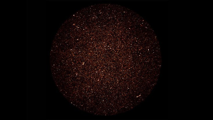 Snímek z malého výseku oblohy na jižní polokouli zobrazuje jako světelné body rádiové vlny z galaxií produkujících hvězdy. Skvrny ve tvaru přesýpacích hodin vznikly chrlením plynů ze supermasivních černých děr v centru některých galaxií