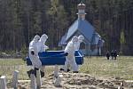 Pohřební zřízenci nesou na hřbitově ve městě Kolpino rakev s obětí koronaviru.