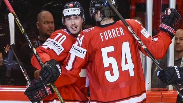 Hokejisté Švýcarska Denis Hollenstein (vlevo) a Philippe Furrer se radují z gólu proti Kanadě.