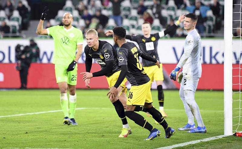 Fotbalista Dortmundu Erling Haaland (uprostřed) se raduje ze svého gólu na hřišti Wolfsburgu