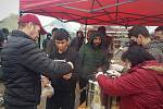 Utečenecký tábor ve slovenských Kútech. Dobrovolníci rozdávájí čaj a potravinový balíček