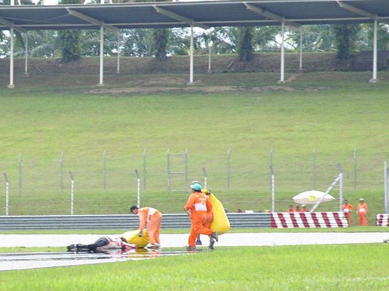 Italský motocyklista Marco Simoncelli leží bezvládně na trati po nehodě v GP Malajsie.