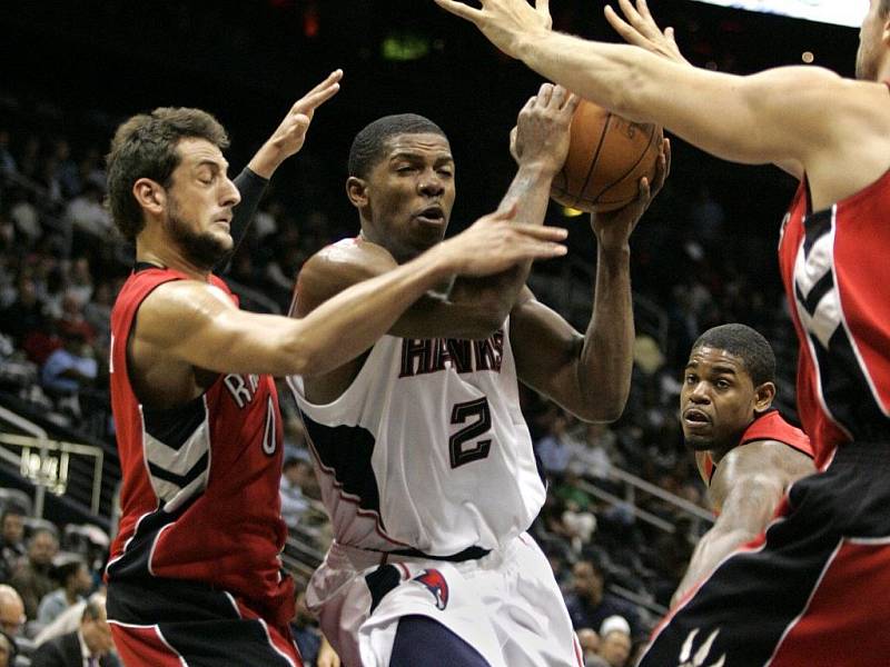 Joe Johnson z Atlanty (uprostřed) se snaží prosmýknout mezi bránícími hráči Toronta.