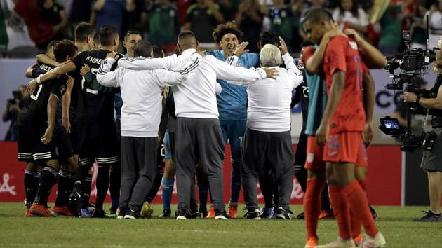 Fotbalisté Mexika se radují z výhry, vpravo zklamaní hráči USA.