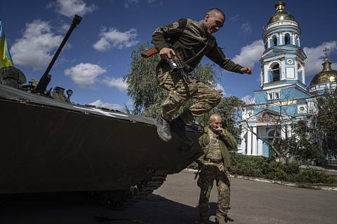 Ukrajinský voják seskakuje z obrněného transportéru v oblasti Izjumu 19. září 2022