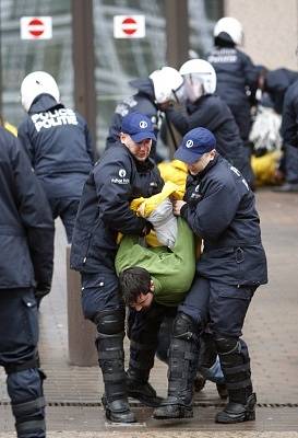 Belgičtí policisté odvádějí demonstranty, kteří oblehli budovu Evropské rady v Bruselu.