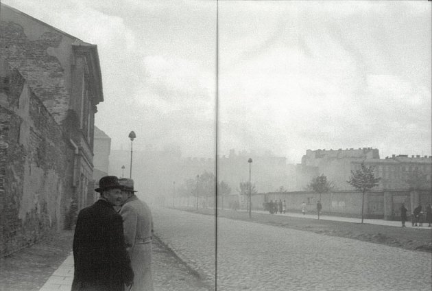 Fotografie Rudolfa Adamce, který šel v době povstání očividně podél zdi ghetta a podařilo se mu zachytit kouř z hořících budov v ghettu a varšavské obyvatele zjišťující, co se děje