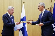 Finský ministr zahraničí Pekka Haavisto (vlevo) a generální tajemník NATO Jens Stoltenberg si předávají přístupové dokumenty v sídle Severoatlantické aliance v Bruselu, 4. dubna 2023