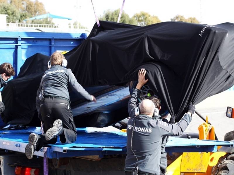 Poničený zakrytý vůz Lewise Hamiltona je připraven na odvoz do boxů..