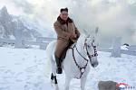 Vůdce KLDR Kim Čong-un na koni zdolává zasněženou posvátnou horu Pektu.