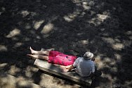 Pár odpočívá na jedné z pařížských laviček během vlny veder, která trápí Francii