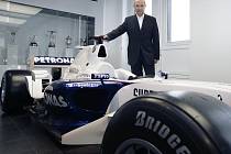 Švýcar Peter Sauber pózuje u staršího modelu vozu formule 1 během tiskové konference.