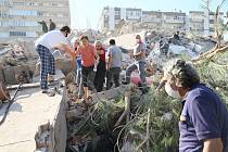Lidé v tureckém městě Izmir prohrabávají sutiny po zemětřesení.