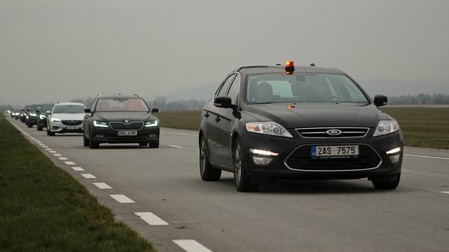 Kolona vozů na obslužné komunikace letiště se zapnutými tempomaty