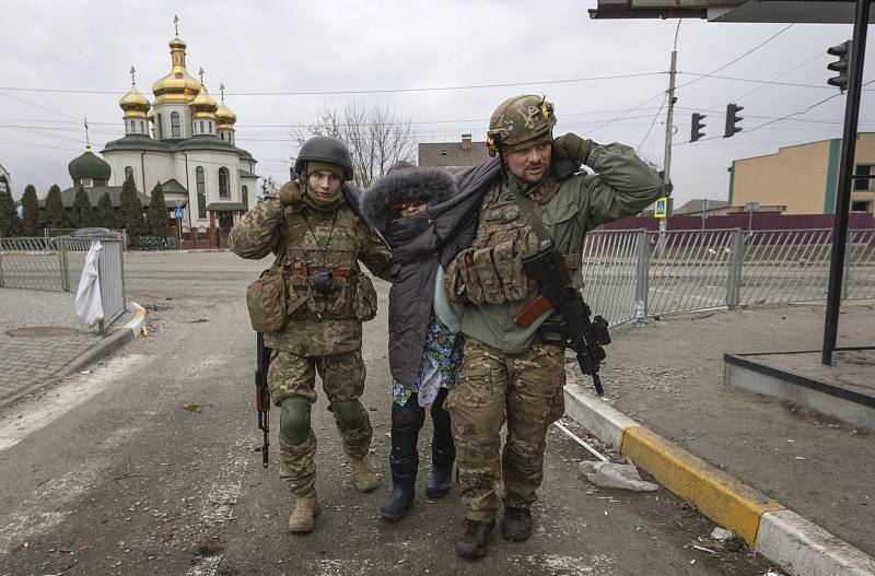 Ukrajinští vojáci pomáhají poraněné seniorce