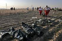 Záchranáři odnášejí tělo oběti nehody ukrajinského letounu, který se dnes zřítil krátce po startu z teheránského letiště