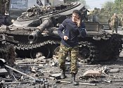 Telefonující ruský voják u zničeného tanku