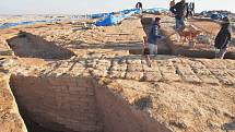 Archeologové a dělníci vykopávají zdi velké budovy ve starověkém městě, která je interpretována jako skladiště z doby říše Mittani.