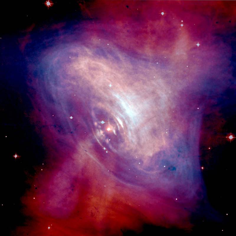 Složený opticko-rentgenový snímek pulsaru Krabí mlhoviny, ukazuje plyny z mlhoviny roztáčené magnetickým polem pulsaru a radiací.