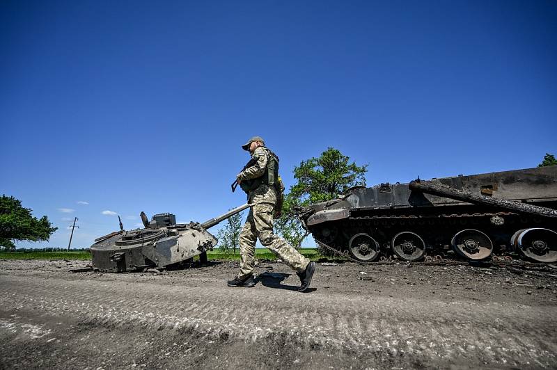 Ukrajinský voják míjí zničený ruský tank v Záporožské oblasti