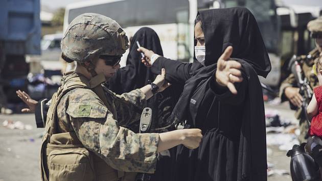 Američtí vojáci kontrolují na letišti v Kábulu civilisty, kteří usilují o evakuaci v jednom z letadel mířících na západ