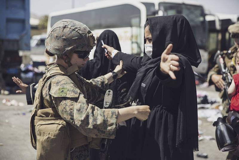 Američtí vojáci kontrolují na letišti v Kábulu civilisty, kteří usilují o evakuaci v jednom z letadel mířících na západ