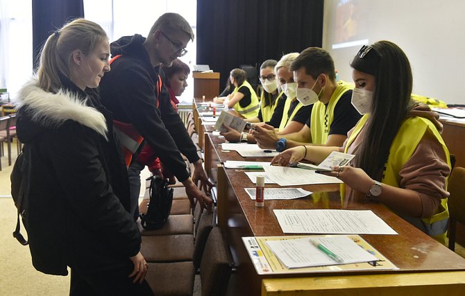 Dobrovolníci (vpravo) pomáhající společně s překladateli s vyplněním vstupních formulářů v Krajském asistenčním centru pomoci Ukrajině v Jihlavě na snímku pořízeném 15. března 2022.
