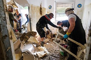 Lidé ve Slovinsku odklízejí bahno a zničené vybavení z domů, které zasáhly bleskové povodně